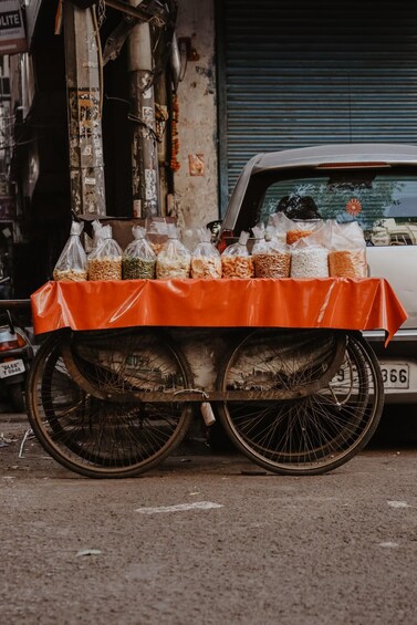 A cart with bags of food items parked in front of a building. 4