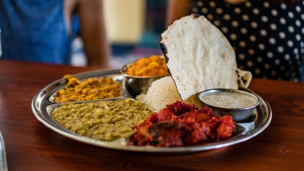 A plate of Indian food with rice, dal, and a piece of roti. 5