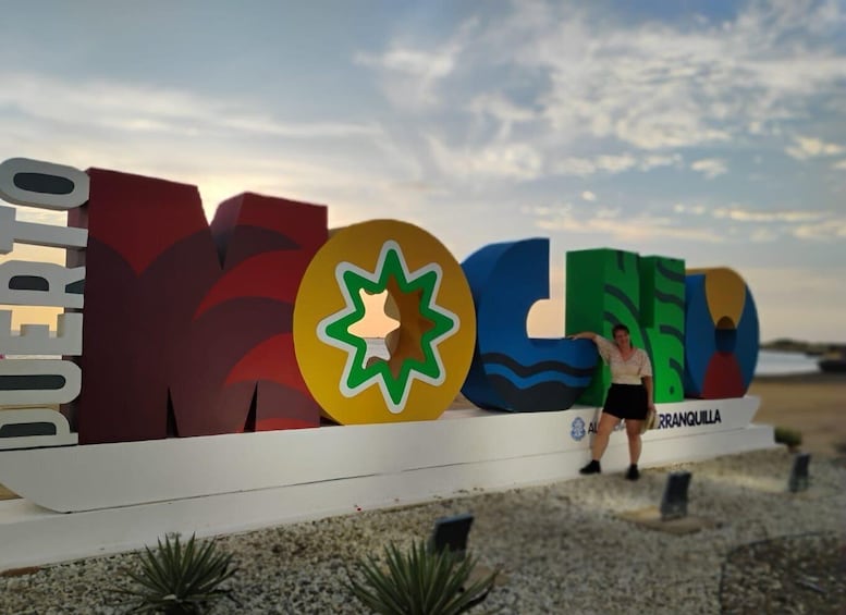 A colorful sign with the word "MOLÉDRAS" and a woman standing beside it. 3