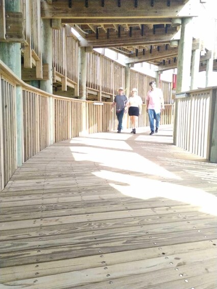 A wooden pedestrian bridge with railings and a wooden floor. 2