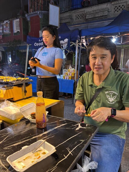 A street food vendor preparing food at a stall. 2