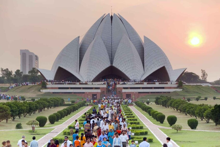 A large, lotus-shaped building with a crowd of people walking towards it. 2