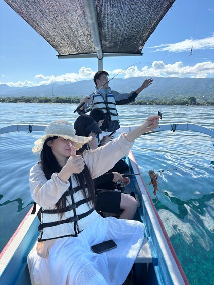 People fishing on a boat with a mountainous landscape in the background. 1