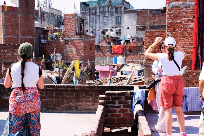 A group of people on a rooftop with brick buildings in the background. 1