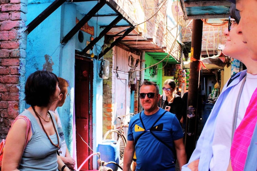 A narrow alley with colorful buildings, a bicycle, and people walking. 5