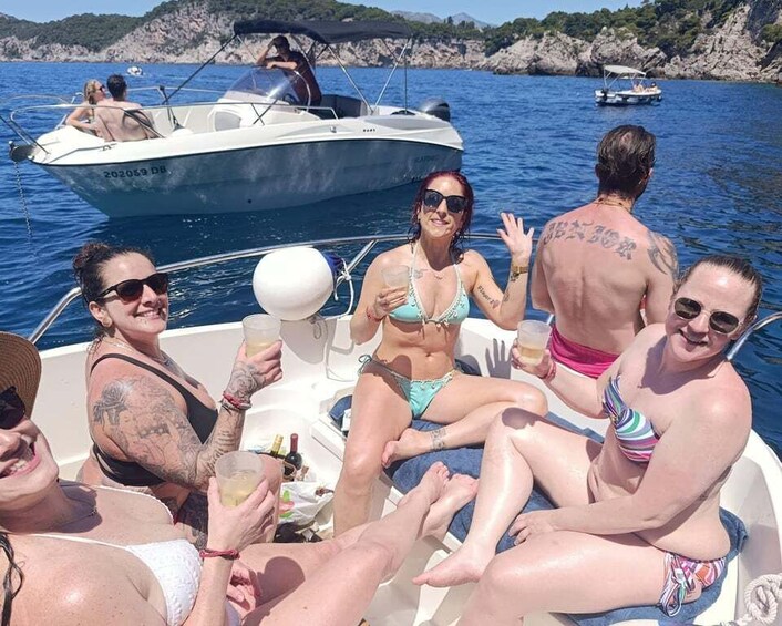 A group of people on a boat, enjoying drinks and the water. 5