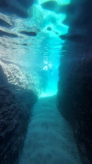 An underwater tunnel with clear blue water and a diver. 3