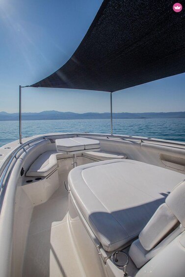 A boat's interior with white cushioned seating and a canopy. 3