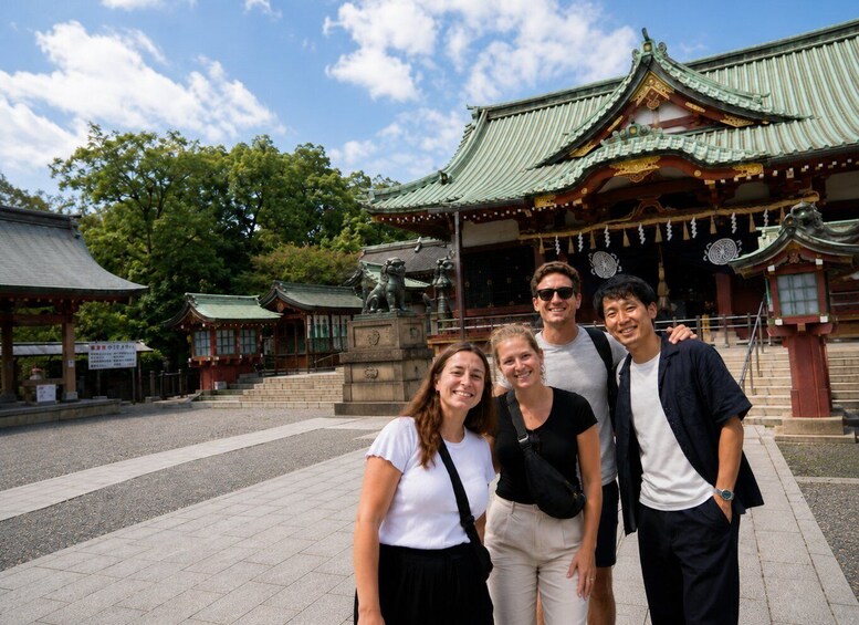 A traditional Japanese temple with a green roof and a statue in front. 5
