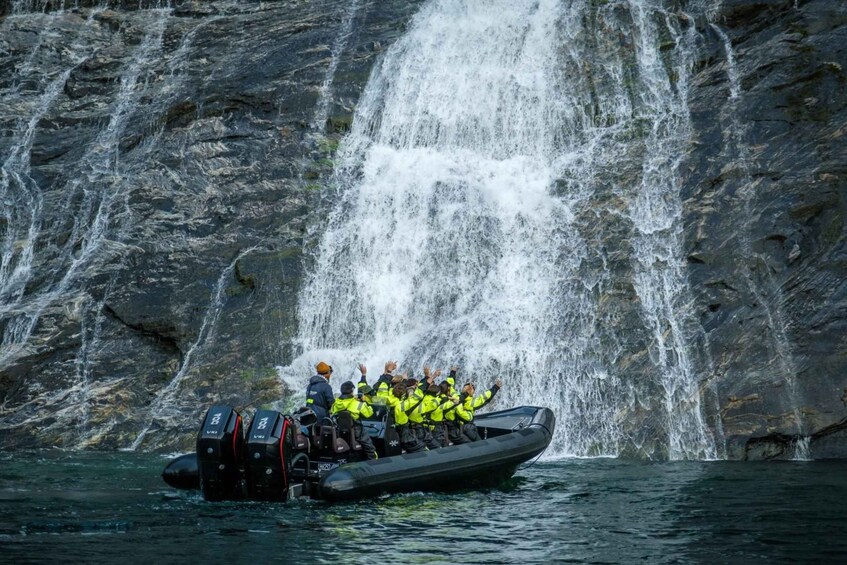 A group of people in a boat near a waterfall. 4