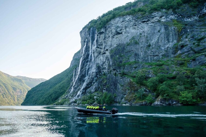 A boat on a calm lake with steep cliffs in the background. 3