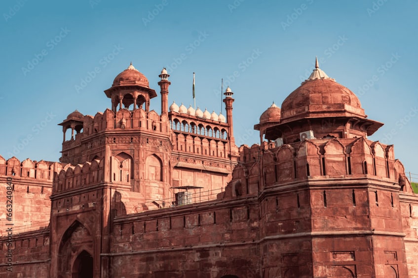 A large, historic red sandstone building with multiple domes and minarets. 5