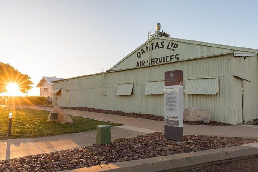 A Qantas Ltd Air Services building with a signboard, surrounded by a gravel path and a grassy area. 1