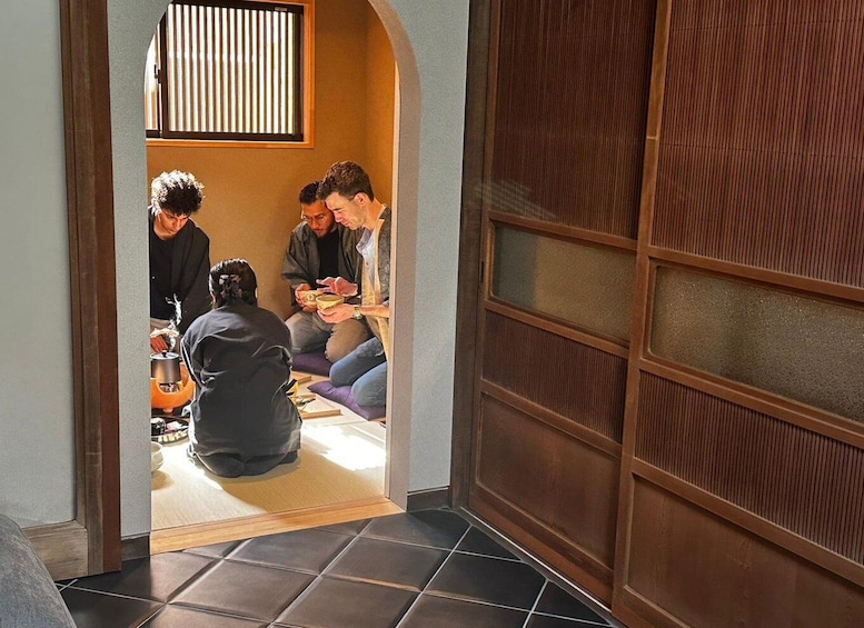A group of people sitting on the floor, engaged in a meal. 1