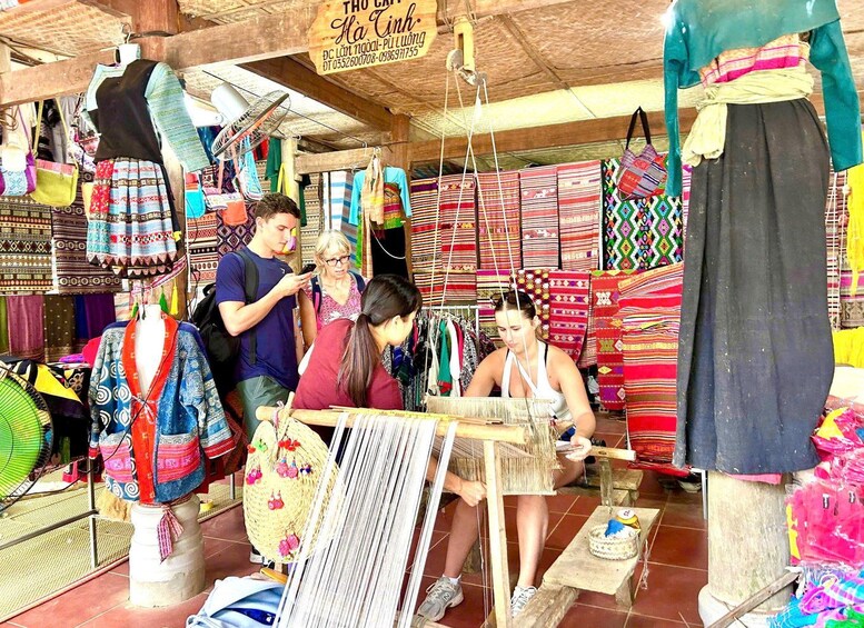 A market stall with colorful textiles and a person weaving. 5