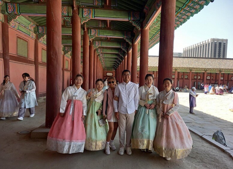 A group of people in traditional Korean hanbok in a historical building with ornate architecture. 5