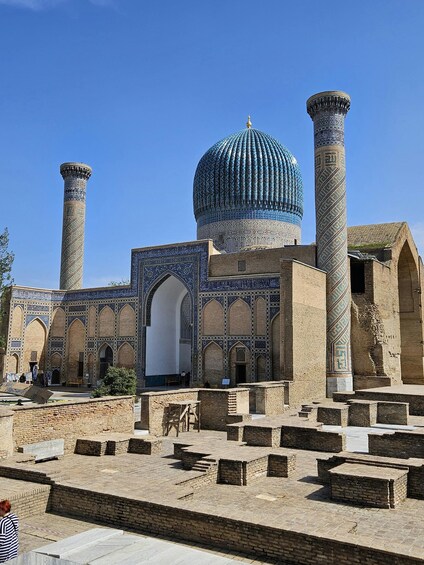 A historic building with a large dome and two tall minarets, featuring intricate blue tile work. 2
