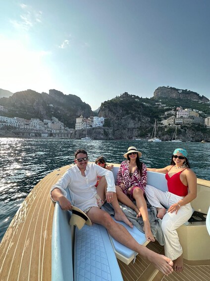 A boat on calm waters with a mountainous coastline in the background. 1