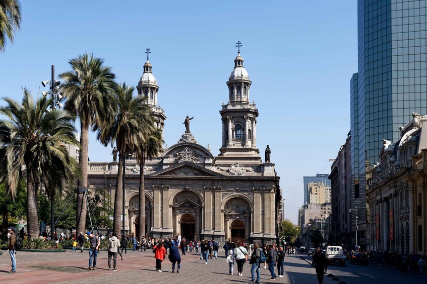 A historic building with two towers and a statue in front. 5