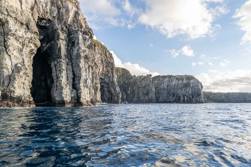 A rocky coastline with a clear blue sea and a prominent cliff formation. 4