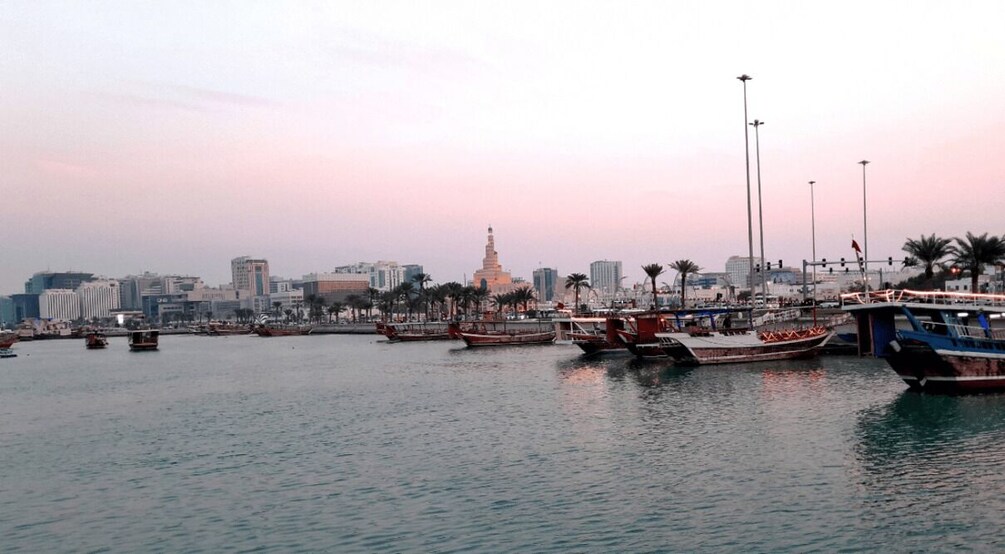 A harbor with boats, a prominent tower, and a city skyline in the background. 2