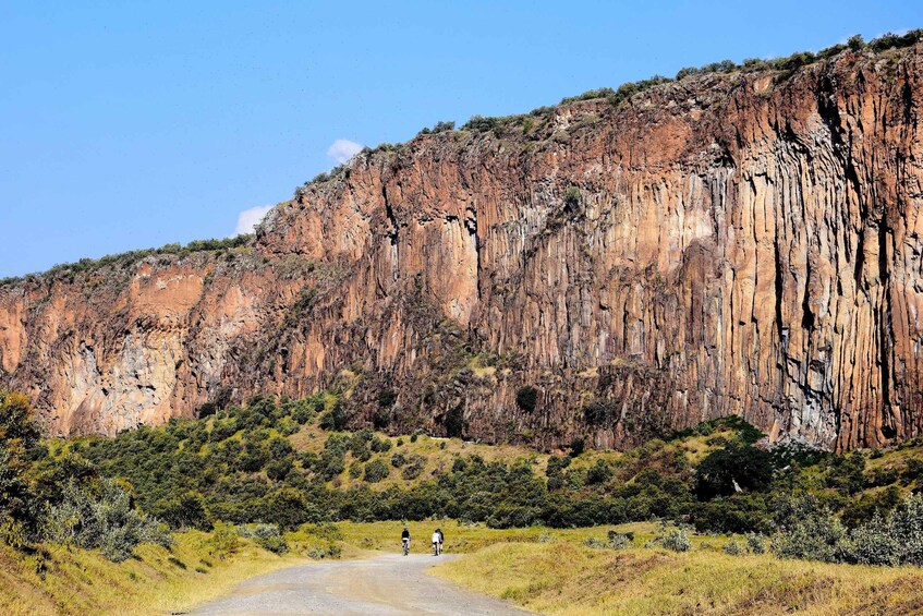 A rugged cliff face with a dirt road leading up to it. 3
