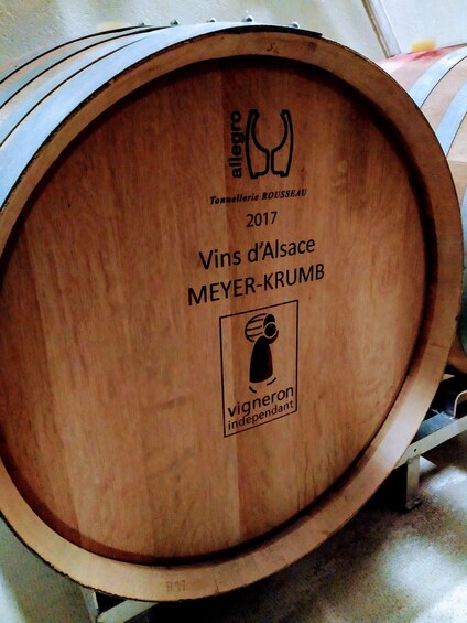 A wooden barrel with text and logos, including 'Tonnellerie ROUSEAU 2017 Vins d'Alsace MEYER-KRUMB' and 'vigneron indépendant'. 2