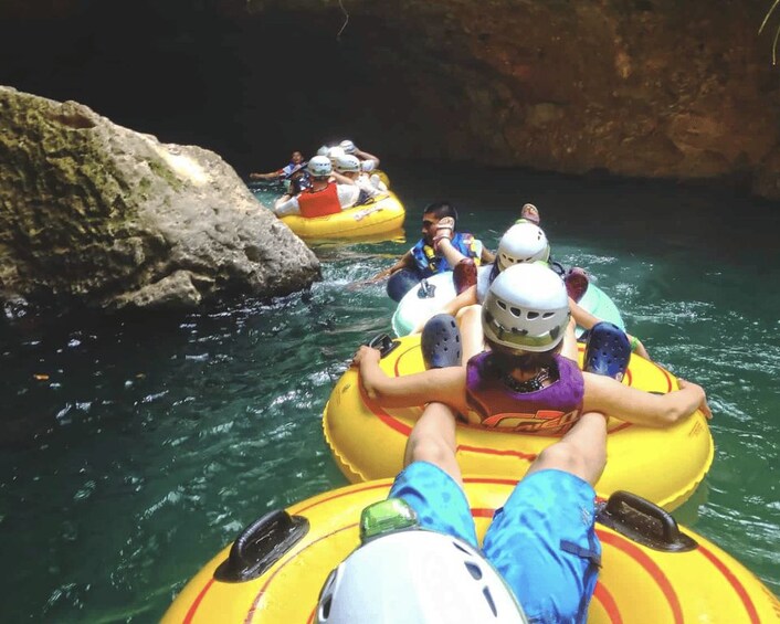 People rafting on yellow inflatable rafts in a river with rocky banks. 2