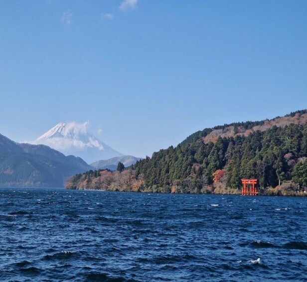 A lake with a mountain in the background and a red torii gate on the shore. 4