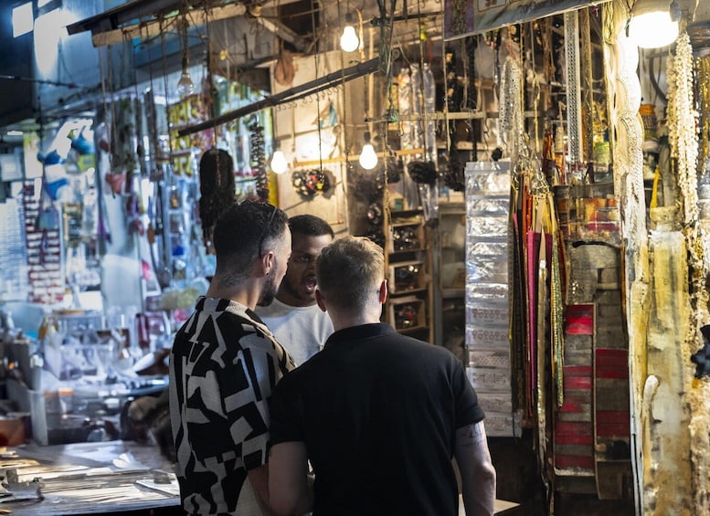 A bustling market with various stalls selling textiles and accessories. 4