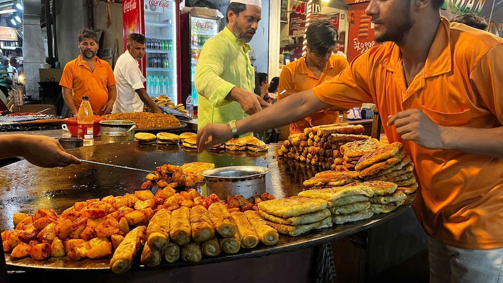A street food vendor preparing and serving various fried snacks. 5