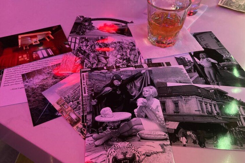 Une table sur laquelle on peut voir différentes photographies, un verre contenant un liquide ambré et un billet d’un dollar. 5