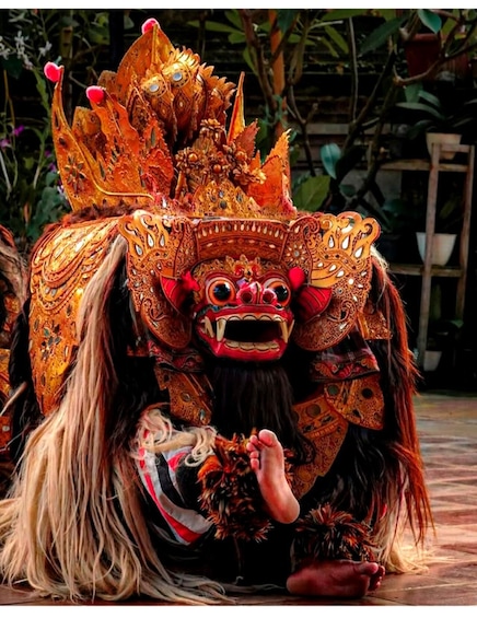 A person in a traditional ornate costume with a large, intricate headdress. 1
