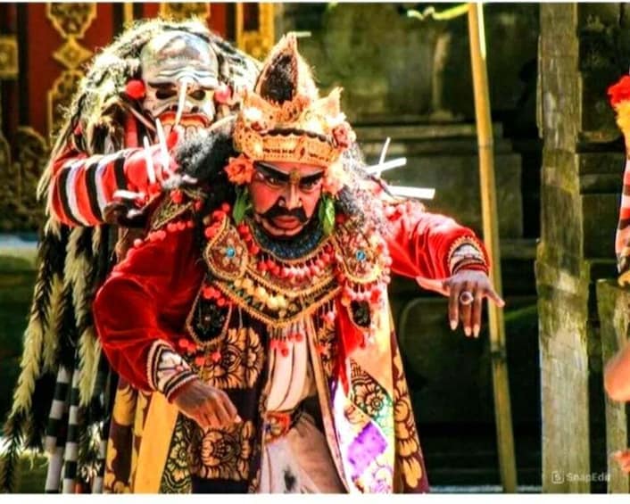 A person in traditional red and gold attire with elaborate headgear, possibly performing a cultural ritual or ceremony. 2