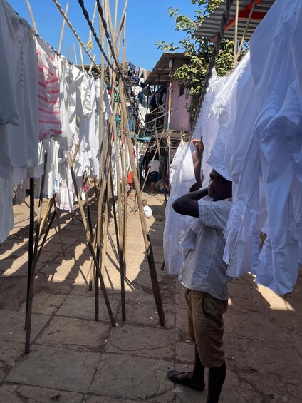 Una persona colgando ropa en un tendedero improvisado en una zona de mercado. 3