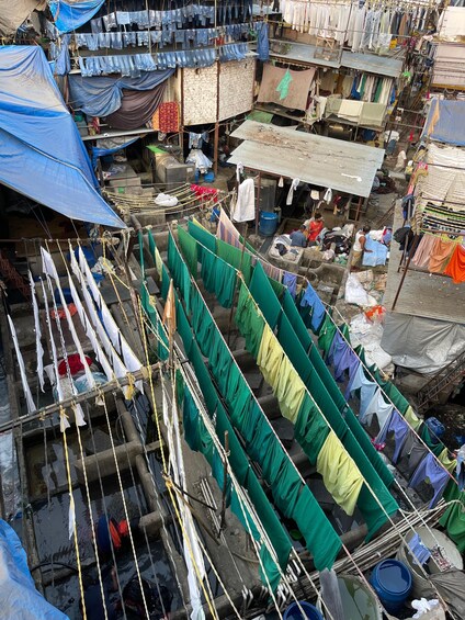Un mercado con gran afluencia de gente, con puestos improvisados y ropa colgada para secar. 5