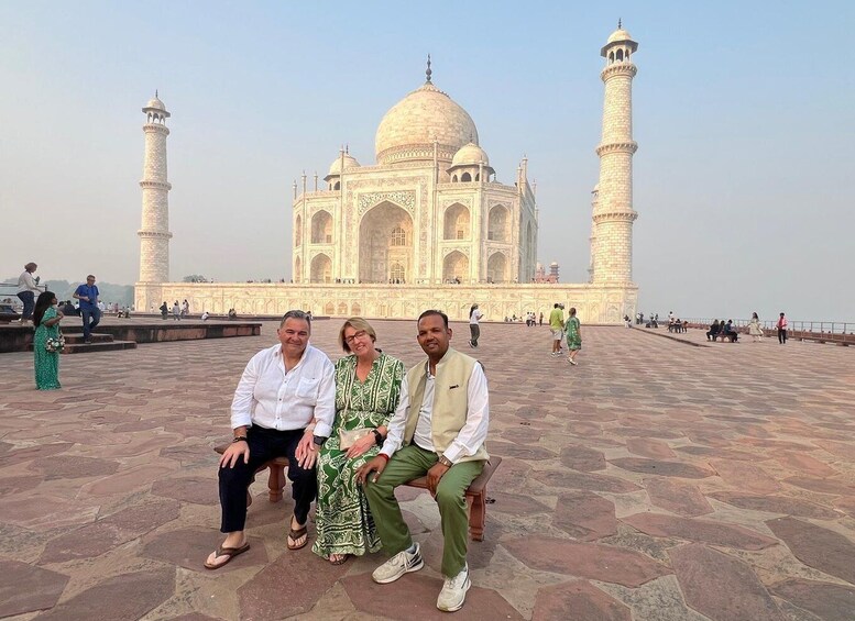 A group of people sitting in front of the Taj Mahal. 4