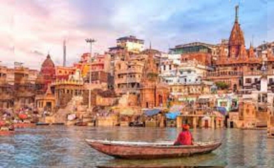 A river with a boat carrying a person, surrounded by densely packed buildings with various architectural styles. 5