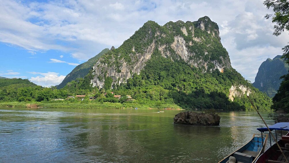 A river with a large mountain in the background and a small boat in the foreground. 2