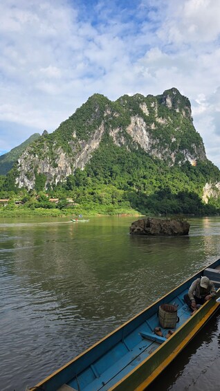 A calm river with a boat, a mountain, and a small island. 3