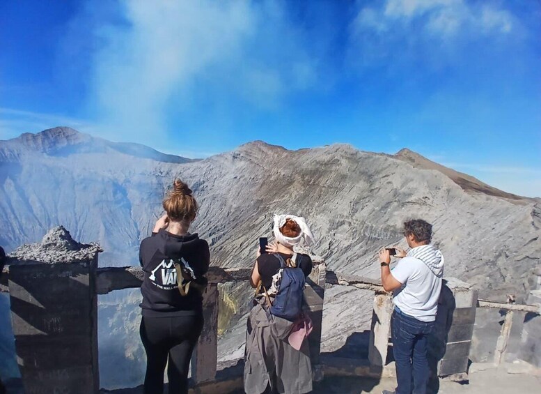 Three people taking photos of a mountainous landscape. 2