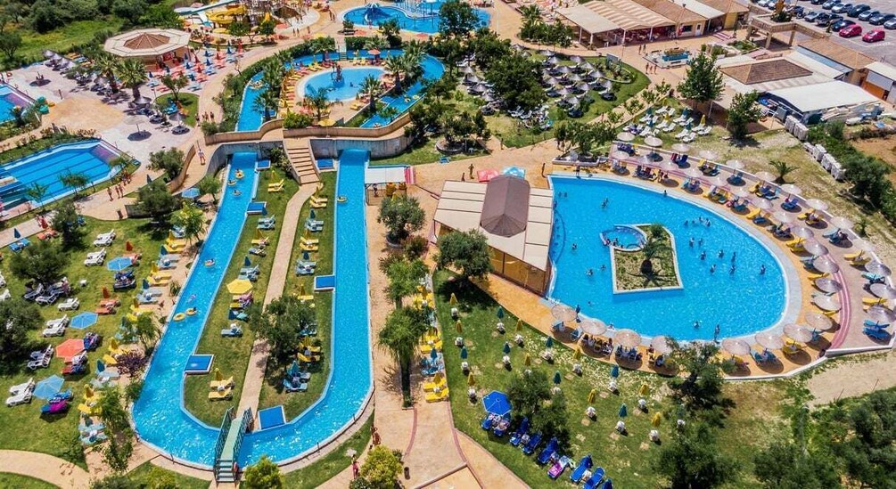 An aerial view of a resort with multiple swimming pools, sun loungers, and umbrellas. 5