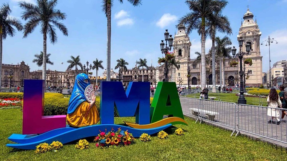 A colorful sculpture with the letters 'LMA' and a person in traditional attire. 1
