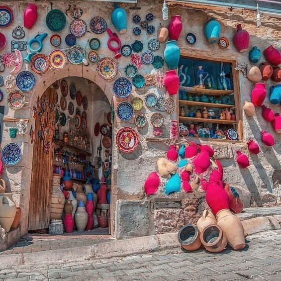 A shop with colorful pottery and ceramics displayed on the walls and outside. 4