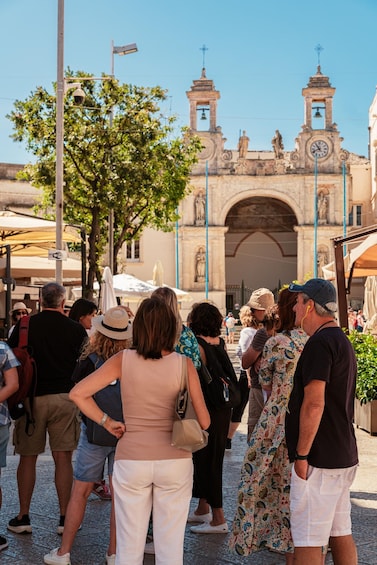 A group of people standing in front of a historic building with two bell towers. 2