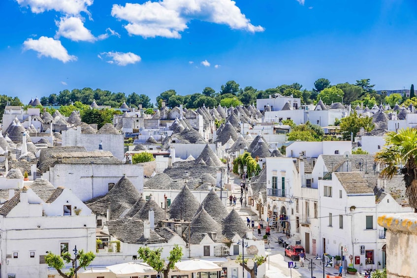A town with white buildings and conical roofs, under a clear blue sky. 1
