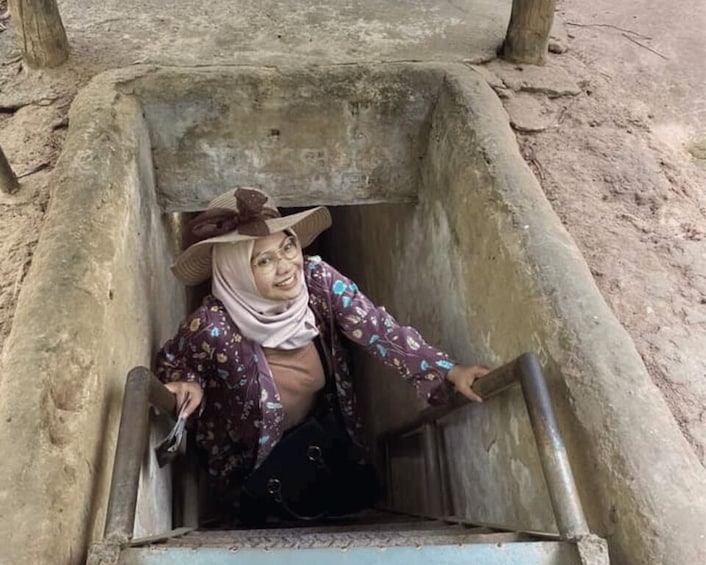 A person sitting inside a concrete well. 2