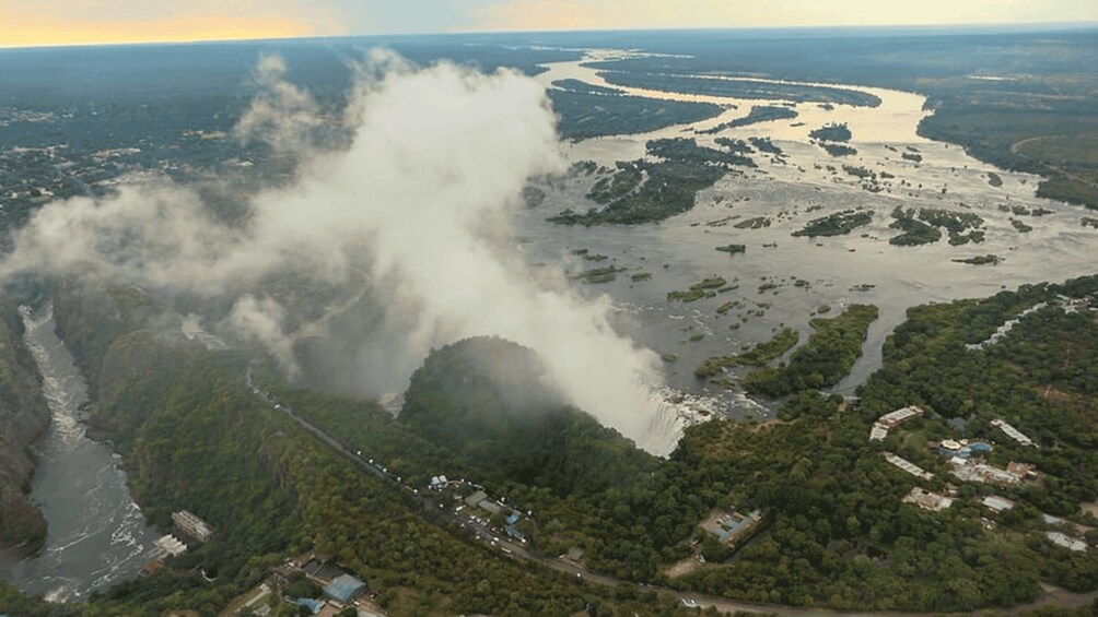 An aerial view of a river surrounded by dense forest and a cloudy sky. 3