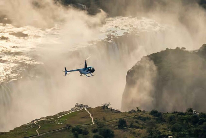 A helicopter flying over a waterfall. 4