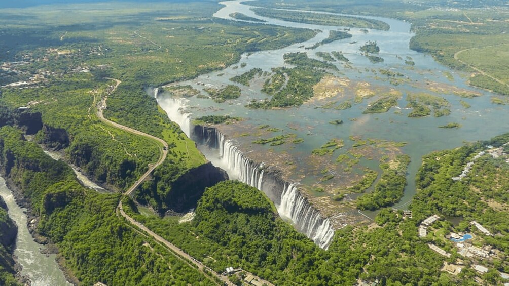A large waterfall surrounded by lush greenery and a winding river. 2